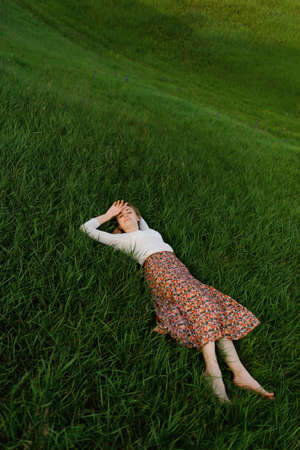Young woman relaxing on the grass in summer
