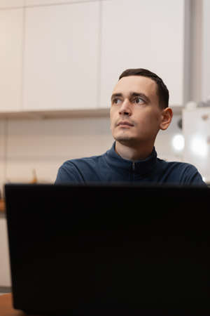 Shot of a thoughtful young man using a laptop while working from home