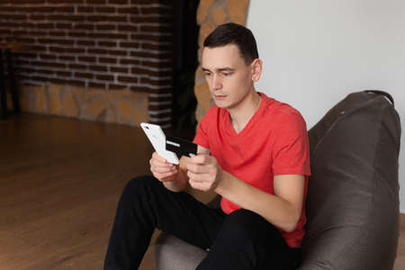 A man making a mobile payment on his phone with credit cardの写真素材