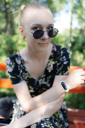 Portrait of blond girl wearing sunglasses and black dressの写真素材