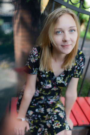 A blond young woman in a park