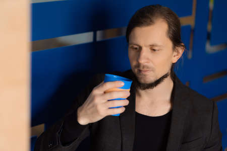 Bearded man drinking coffee from an eco cup