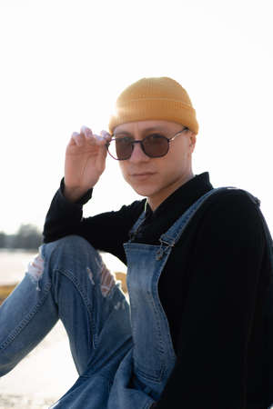 Portrait of a young man in a yellow hat and sunglassesの写真素材