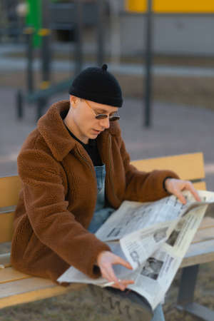 A smoking man is reading a newspaperの写真素材