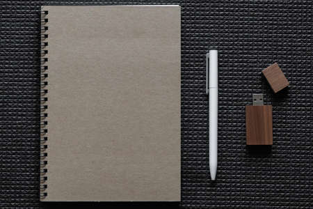 Notebook, pen, and USB stick on a table. high quality photoの写真素材