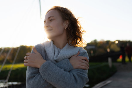 Smiling, cheerful young woman relaxing on a lake enjoying the spring sunshine. spring walk. Nature....