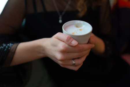 A cup of coffee held in the girl's hands. high quality photo