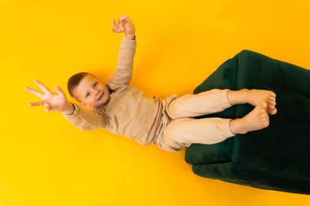 Little boy lying on his back waving his armsの写真素材