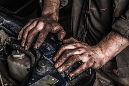 Working men with dirty hands stay near car engine