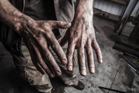 Dirty hands of mechanic at car station