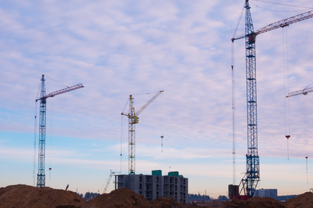 Crane and building construction site at sunset, sunriseの写真素材