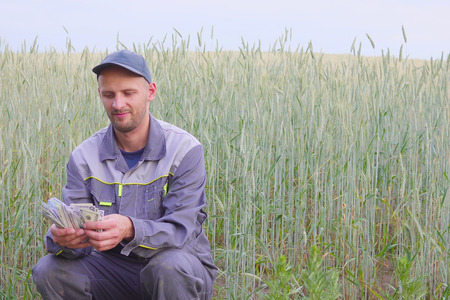young farmer has a lot of money. The concept of success of business in agriculture.