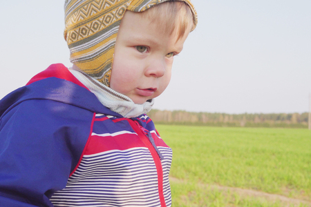 one year old boy farmer standing in the field with young wheatの写真素材
