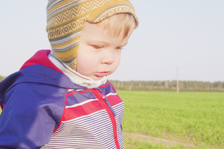 one year old boy farmer standing in the field with young wheatの写真素材