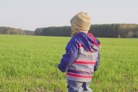 one year old boy farmer standing in the field with young wheatの写真素材