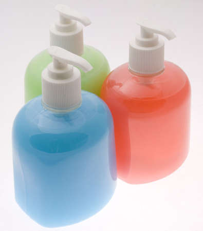 Three bottles filled with different coloured liquid soapの写真素材