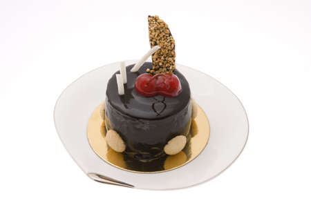 Chocolate cake with two cherries on a white plateの写真素材