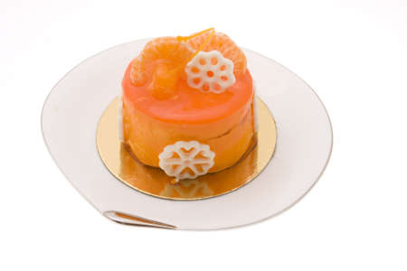 Orange cake with a cherry on a white plateの写真素材