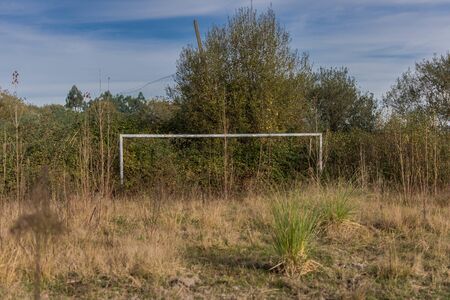 Old soccer goal in an abandoned soccer field with a lot of undergrowthの写真素材