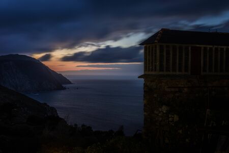 Cliff in the coastline at sunset with blue colors in the clouds