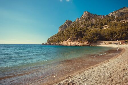 Beach with turquoise water, rocks and trees