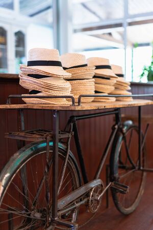 stack of straw hats on top of a bicycle at a weeding eventの写真素材