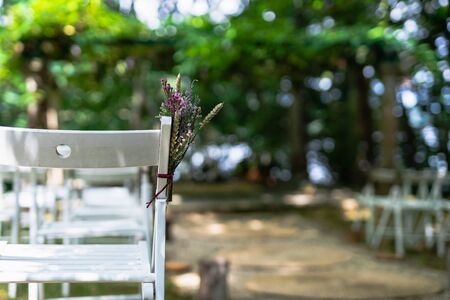 Floral decoration in a chair at wedding ceremony in the green woodsの写真素材