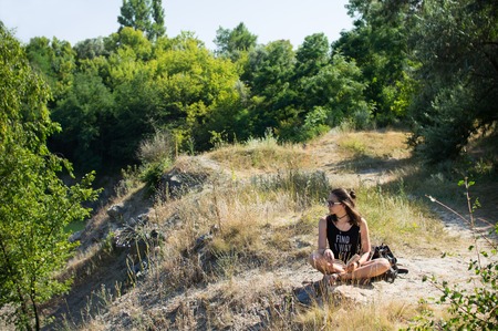 Young girl sitting on the edge of the cliffの写真素材