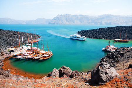 There are volcano cruises and short trips from Fira with a boat and a lot of tourists visit the volcanic landscapeの写真素材