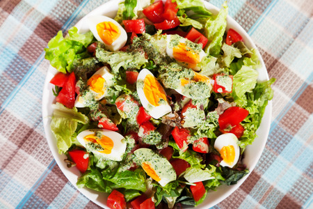 Summer salad with tomatos and boiled eggs and creamy dressingの写真素材