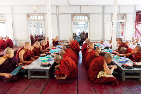 Mandalay, Myanmar - February 27, 2011: Monks from Mahagandayone monastery eating their morning meal which is food prepared from the local people in the village のeditorial素材