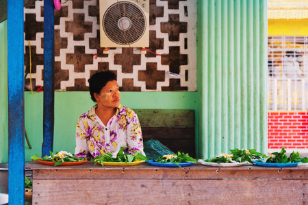 Yangon, Myanmar - February 24, 2011 : Senior Burmese woman selling freshly cooked food on the streetのeditorial素材