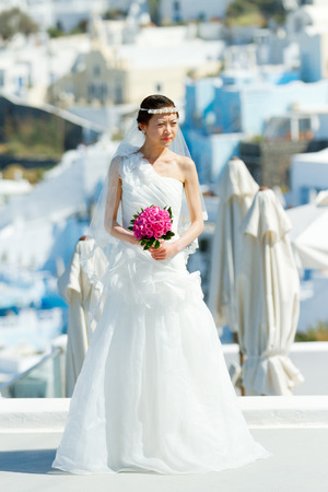 Firostefani, Greece - May 05, 2012 : Young asian bride on a photo session early in the morning before the tourist are on the streets.のeditorial素材