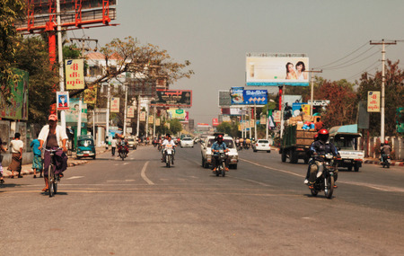 Mandalay, Myanmar - February 27, 2011 : Local Burmese riding motorcycles in a big street in Mandalay early in the morning, going to workのeditorial素材