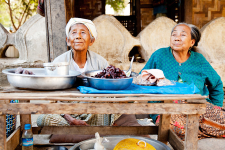 Mingun, Myanmar - February 28, 2011 : Two Burmese old women selling cooked food and snacks to the touristsのeditorial素材