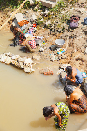 Heho, Myanmar - February 28, 2011 : Burmese people taking bath and washing clothes in the dirty waters of the lakeのeditorial素材