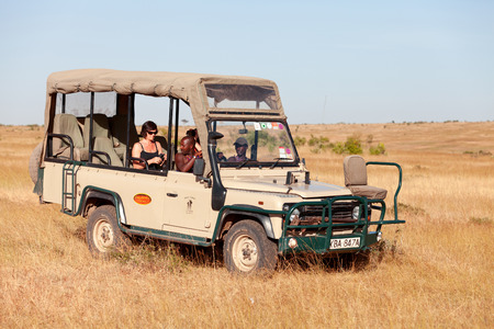 Masai Mara, Kenya - February 15, 2012 : Tourists in a safari jeep looking around and trying to see lionsのeditorial素材