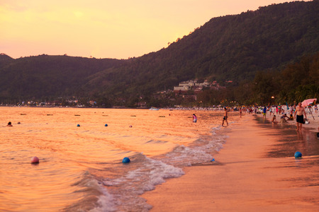 Phuket, Thailand - March 16, 2011 : Tourists enjoying colorful sunset on the beach at the end of the day.のeditorial素材