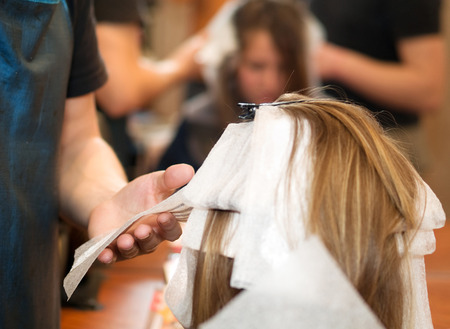 Young woman at the hair studio, having her hair paintedの写真素材