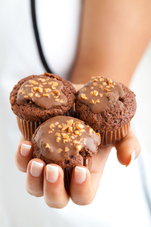 Chocolate muffins in womans hand, close upの写真素材