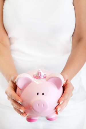 Younw woman holding pink pig money-box - Piggy Bankの写真素材