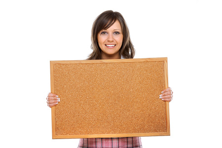 Young woman holding an empty board and smiling, isolated over white backgroundの写真素材