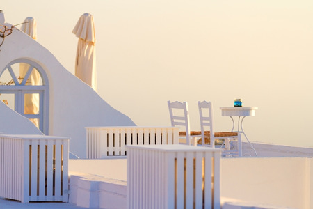 Perfect white summer villa in Firostefani, Santorini at sunset with a terrace looking at the volcano