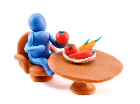 Clay man on a table having lunchの写真素材