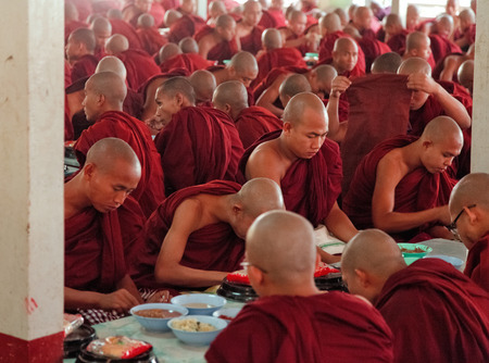 Mandalay, Myanmar - February 27, 2011 : Monks from Mahagandayone monastery eating their morning meal which is food prepared from the local people in the villageのeditorial素材