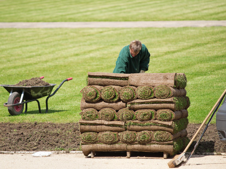 London, United Kingdom - April 30, 2008 : Middle aged man planting turf grass rolls in Greenwich parkのeditorial素材