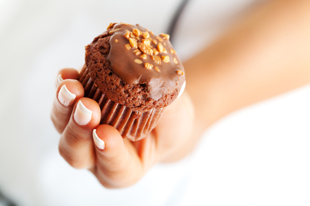 Chocolate muffin in woman's hand, close upの写真素材
