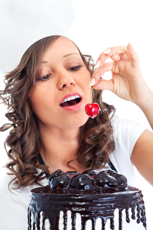 Young chef woman holding chocolate cake, isolated on whiteの写真素材