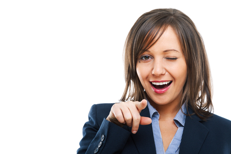 Businesswoman pointing with a finger and winking isolated on white backgroundの写真素材