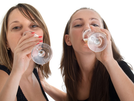 Girls celebrating with champagne isolated on whiteの写真素材